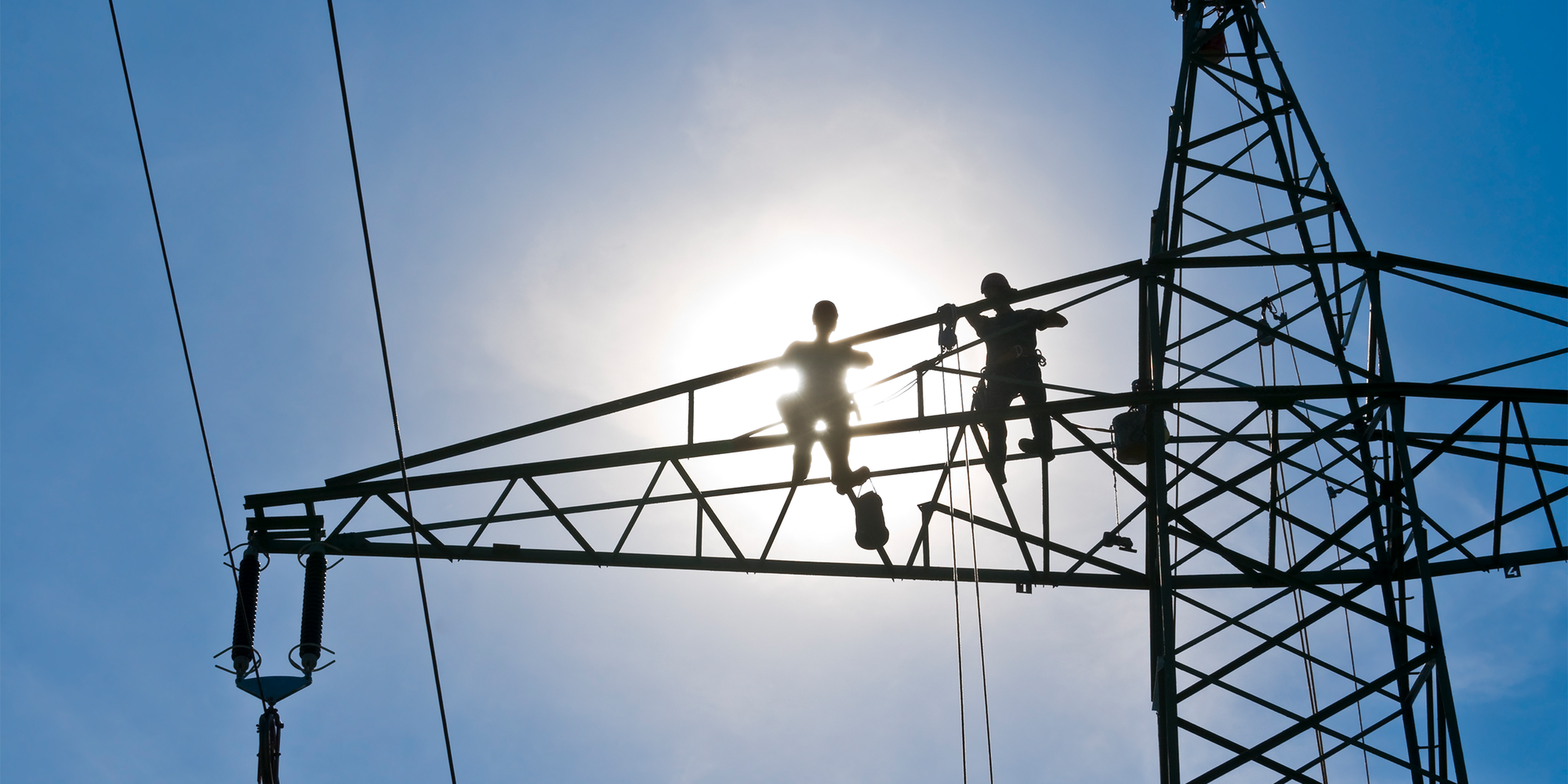 Wie Elektrifizierung den Versorgungsschock bei fossiler Energie dämpfen kann: Arbeiten an Strommast